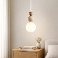Suspension design nordique composée de trois sphères empilées en bois, travertin beige et verre dépoli.